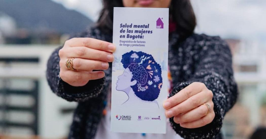 Mujer sosteniendo folleto de la Secretaría de la Mujer