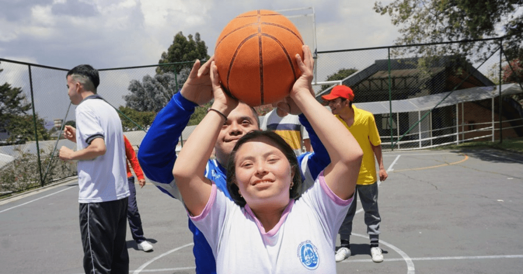 Imagen de un niño y una niña jugando baloncesto