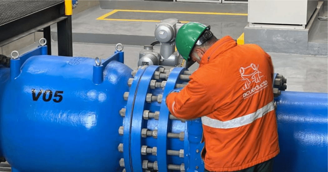 Imagen de un técnico de la empresa de Acueducto realizando mantenimiento en un tubo de alcantarillado.
