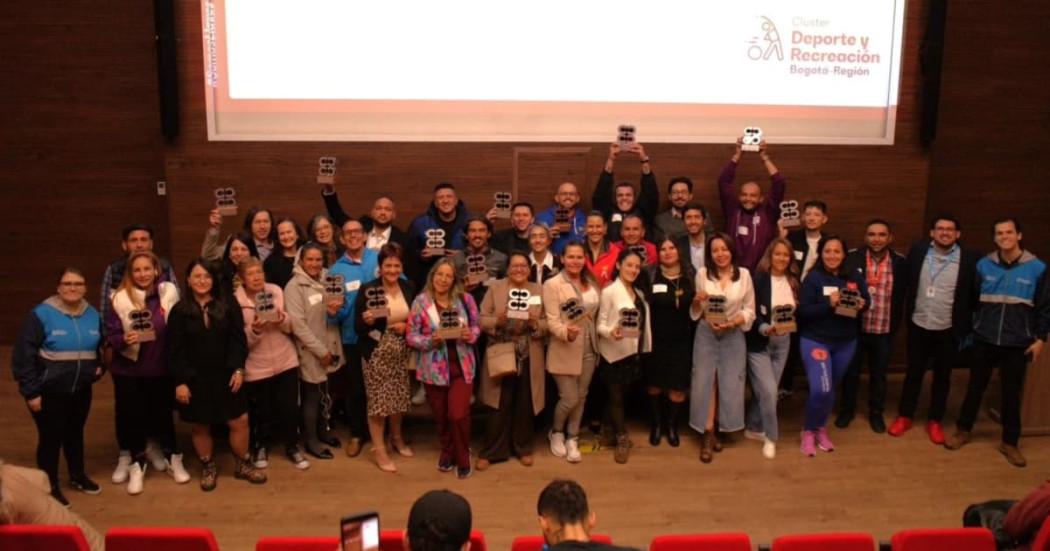 Foto de personas en ceremonia de reconocimiento de 'Deporte al Barrio'.