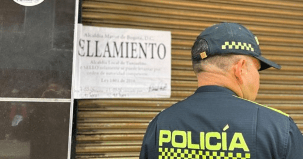 Imagen de un aviso de sellamiento y en primer plano la espalda de un policía