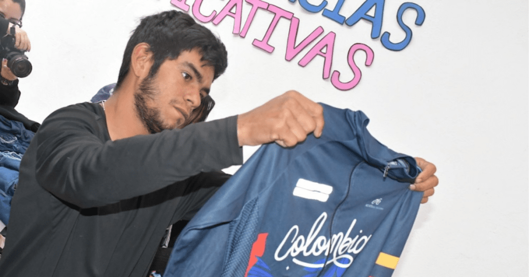 Imagen de un hombre sosteniendo y mirando una camiseta