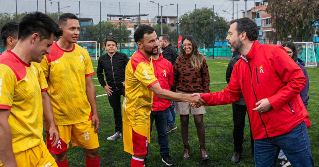 Imagen del alcalde Galán dándole la mano a un futbolista amateur en la cancha de Bilbao