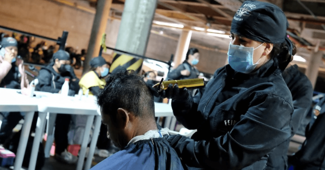Imagen de una persona peluqueando a un habitante de calle
