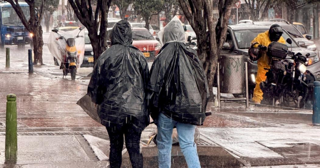 Foto que muestra personas caminando bajo la lluvia 