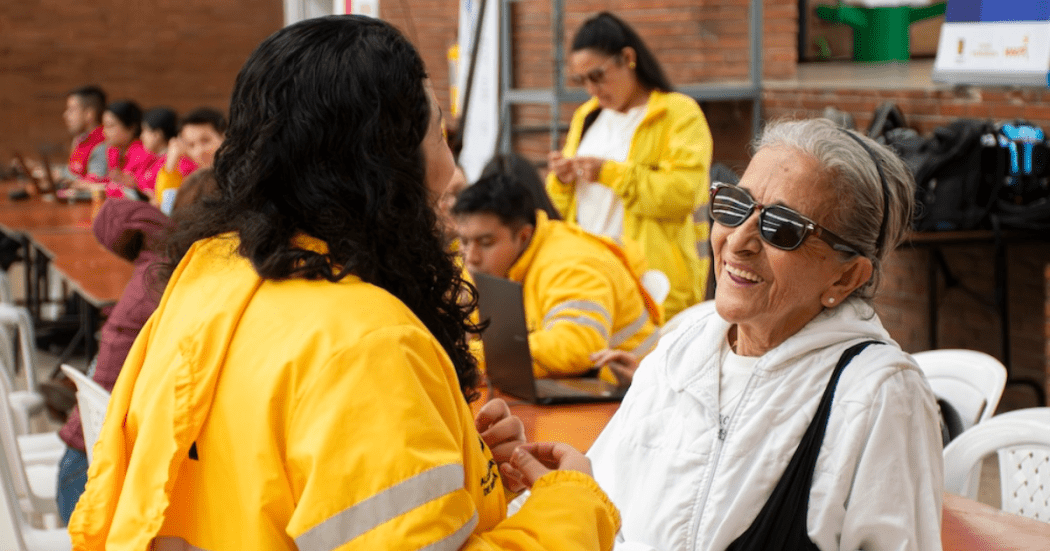 Imagen de una señora sonriendo junto a una funcionaria de Integración Social