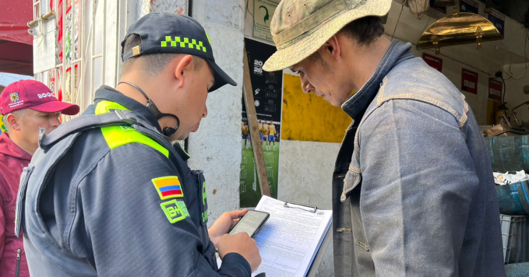 Foto de un policía sellando un establecimiento en Bogotá