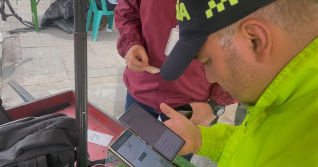 Uniformado de la Policía haciendo verificación e inspección a carreta de compra y venta de celulares robados