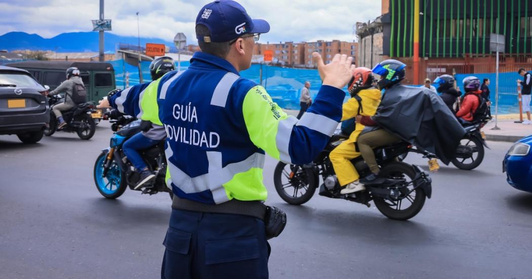 Foto que muestra un agente de transito y vehículos andando
