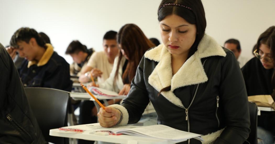 Foto que muestra personas escribiendo en un papel 