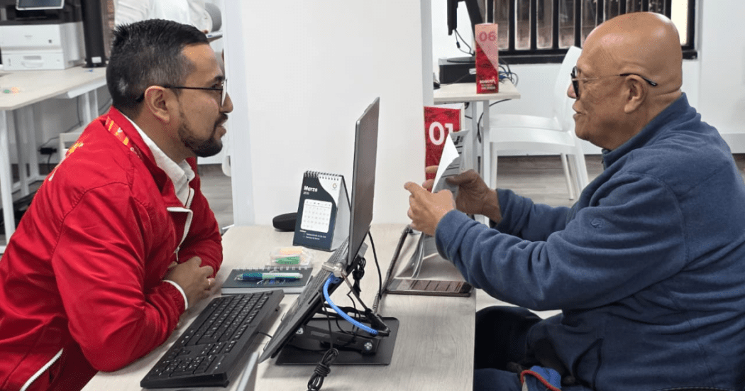 Foto de un funcionario ayudando a un ciudadano con discapacidad