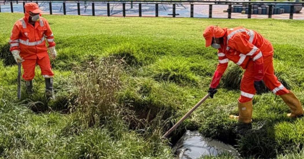Trabajadores de Aguas Bogotá limpiando zonas verdes