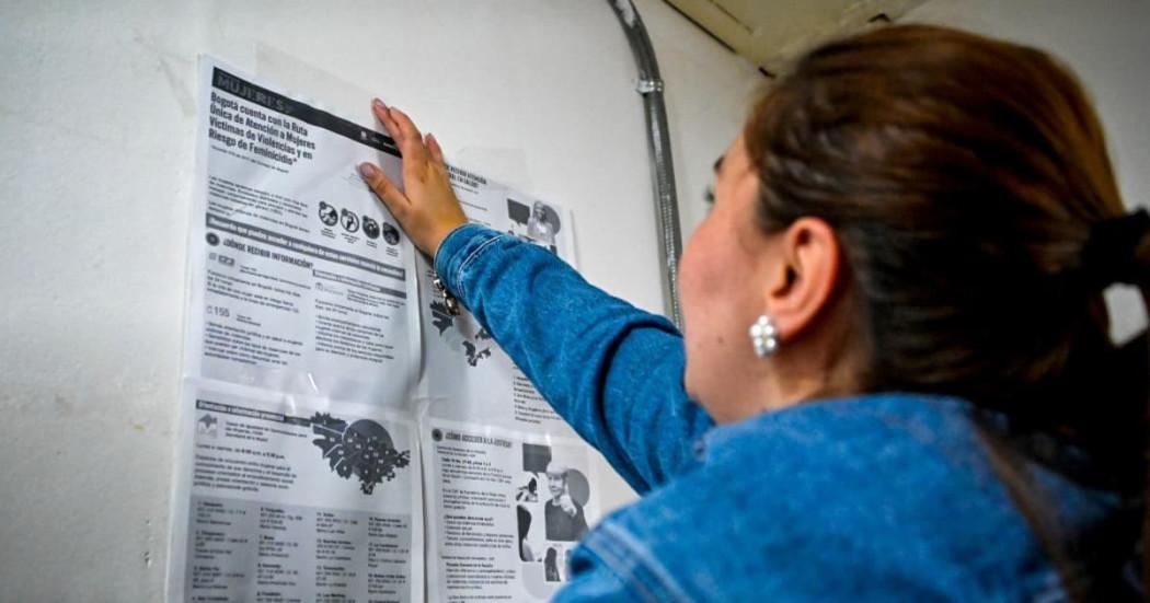 Una mujer pegando información en una pared