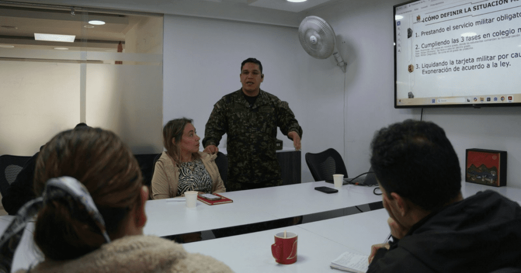 Imagen de una señora junto con un militar durante una reunión