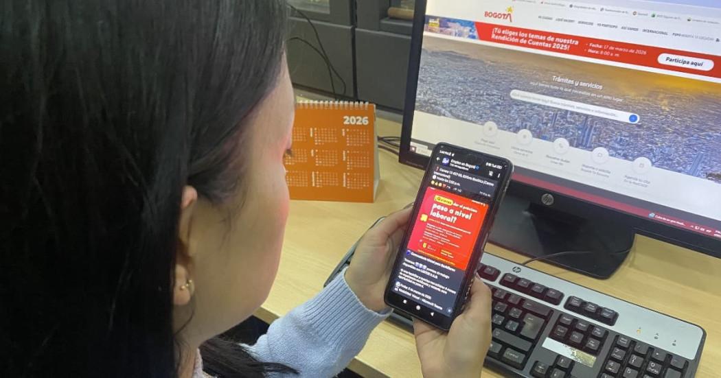 Foto de una mujer consultando en su celular el canal de WhatsApp Empleo en Bogotá.