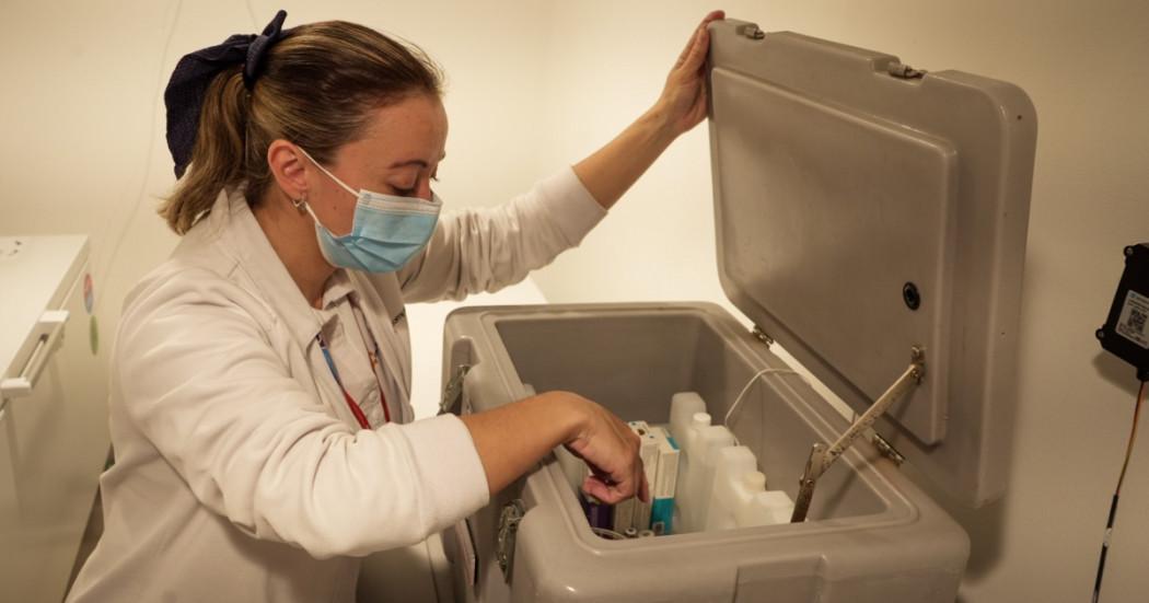 Foto que muestra una enfermera revisando unos recipientes