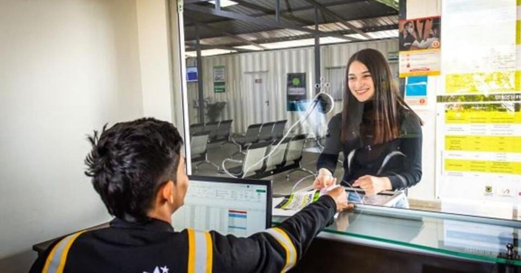 Foto de una mujer y un hombre en una ventanilla de atención de servicios de movilidad en Bogotá.