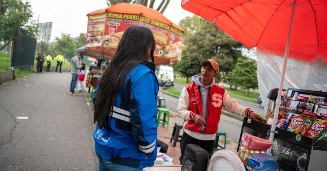 Foto de vendedores informales junto a un gestor social del IPES en Bogotá.