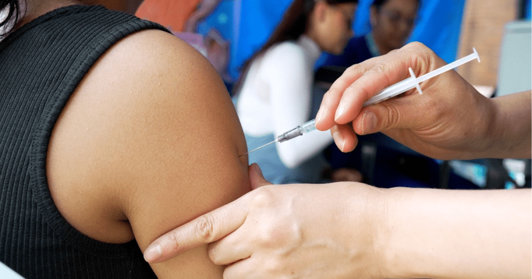 Foto que muestra una enfermera colocando una vacuna