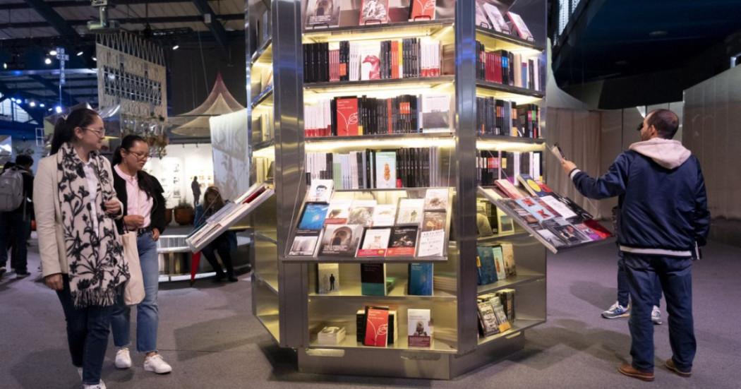 Imagen de personas viendo stand de libros en la FILBo