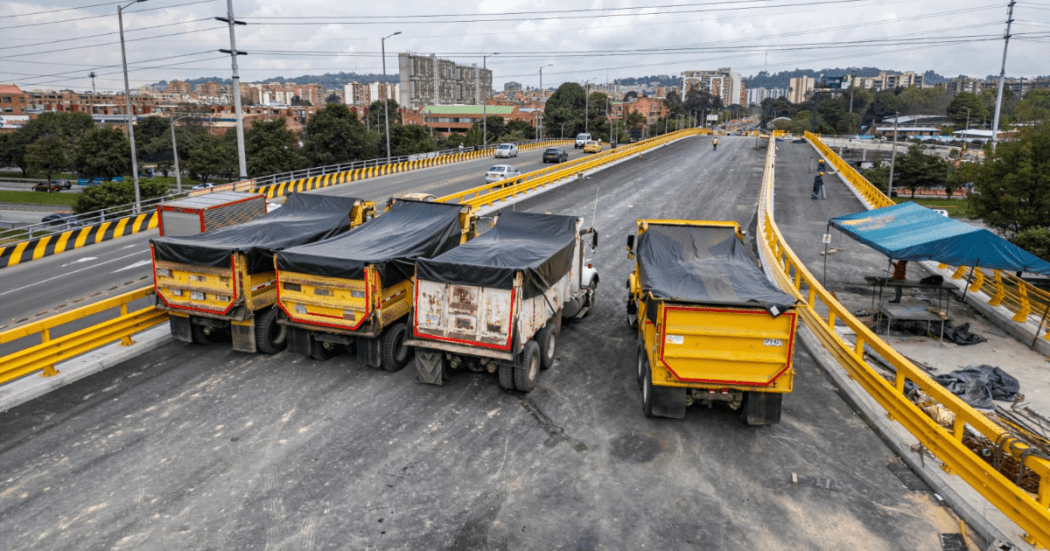 Imagen de tres volquetas en el puente de la 153