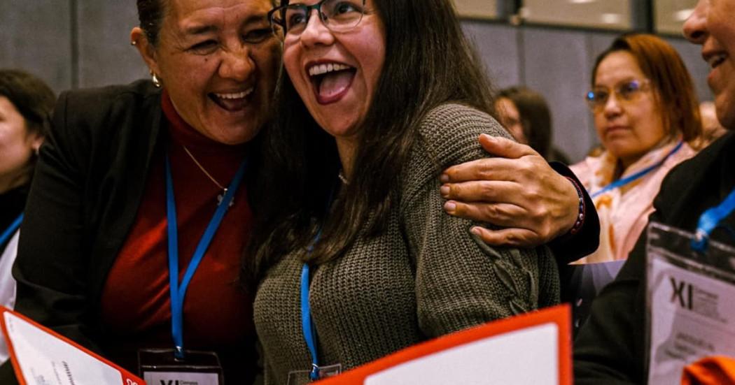 Foto de mujeres abrazandose y sonriendo.