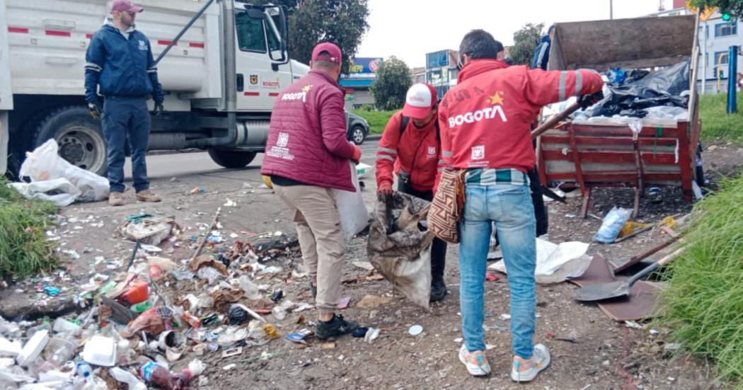 Hombres recogiendo residuos en punto intervenido.