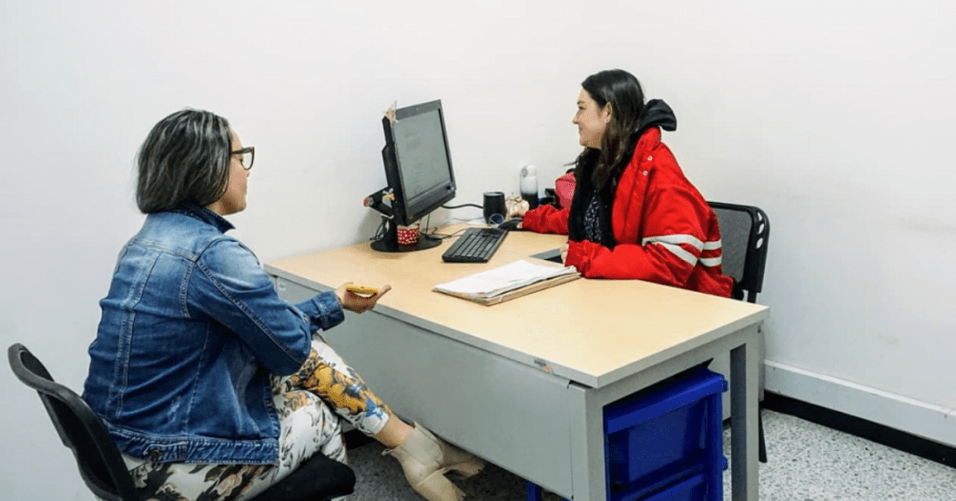 Imagen de una funcionaria atendiendo a una mujer