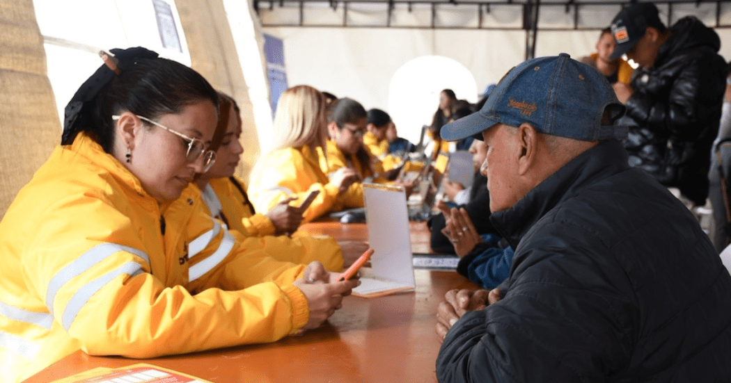 Imagen de una funcionaria mirando el celular con un señor
