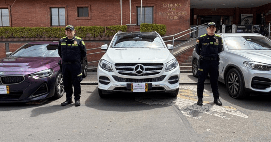 Imagen de dos policías junto a los vehículos recuperados