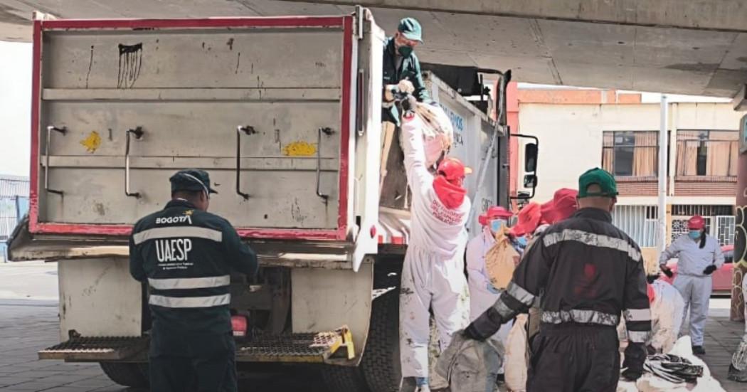 Foto que muestra personas recolectando residuos en una volqueta