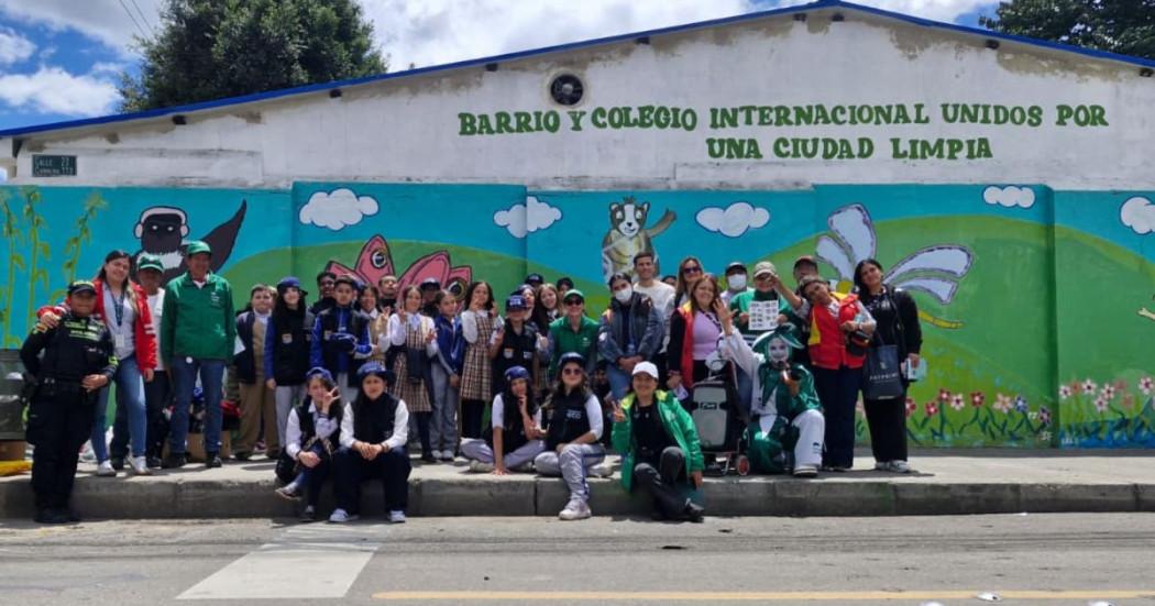 Estudiantes, comunidad y funcionarios frente al mural del Día de la Tierra