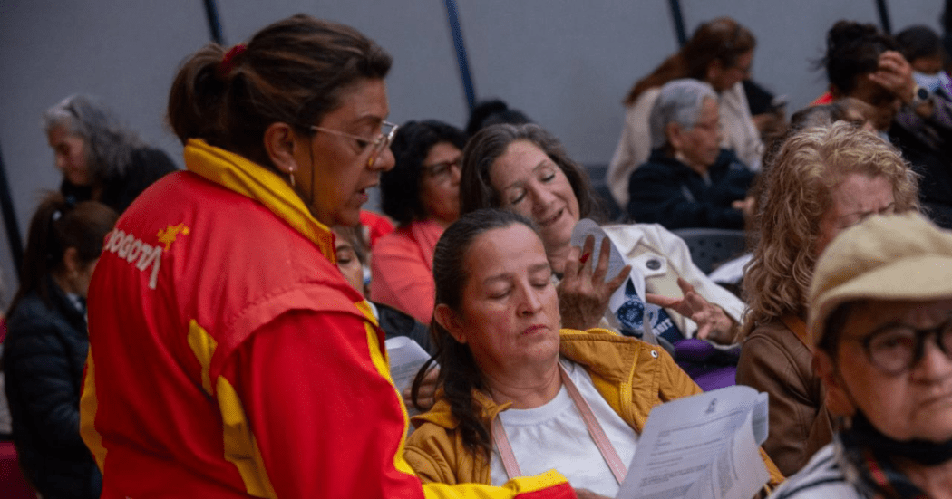 Imagen de una funcionaria pública hablando con una señora de la comunidad