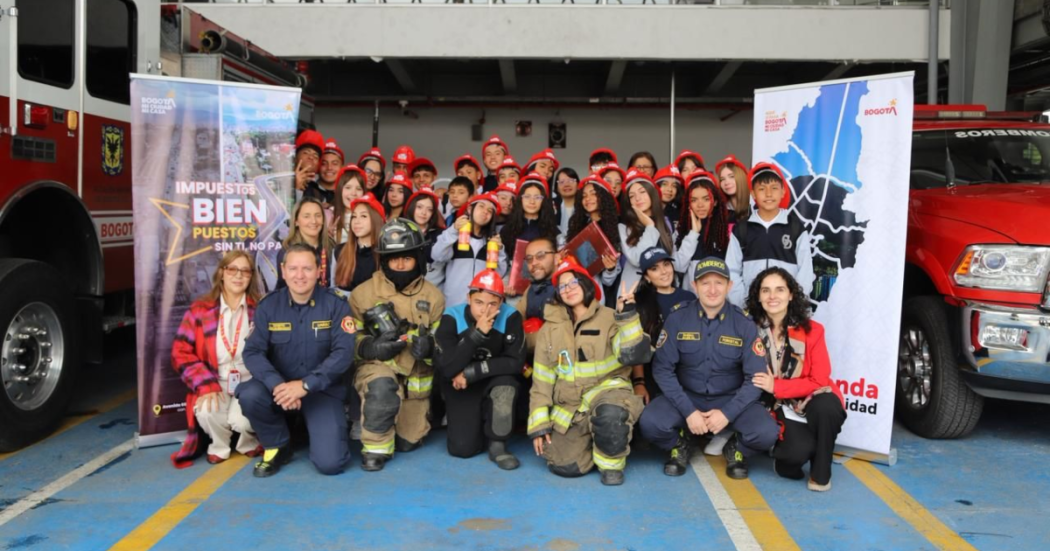Imagen de niños y niñas posando para una foto en la estación de Bomberos