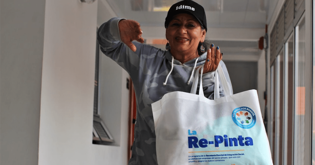 Imagen de una mujer sonriendo y sosteniendo un talego con ropa