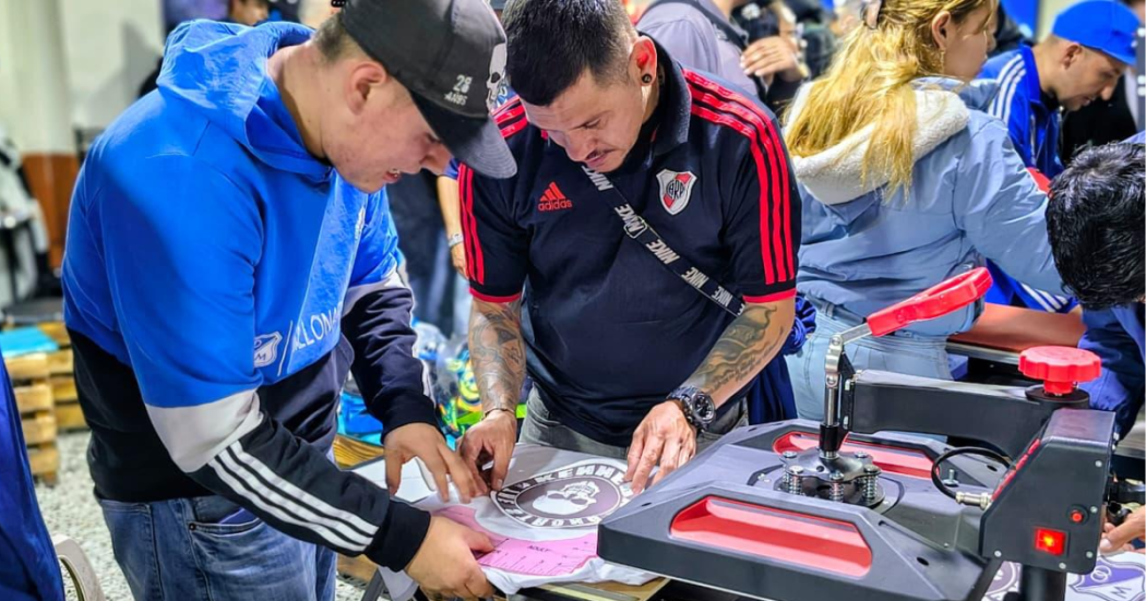 Foto de dos personas estampando una camiseta 
