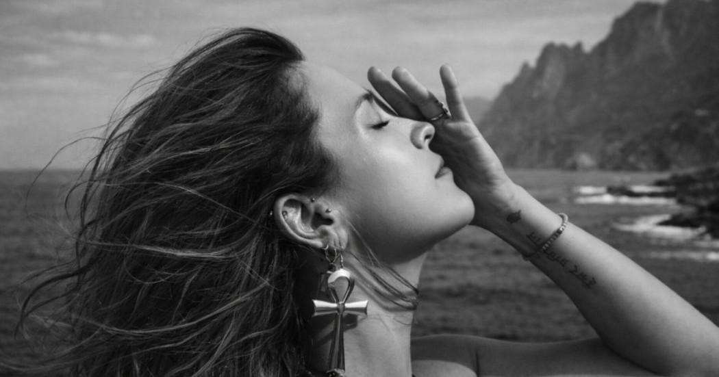 Imagen de mujer con los ojos cerrados en el mar.