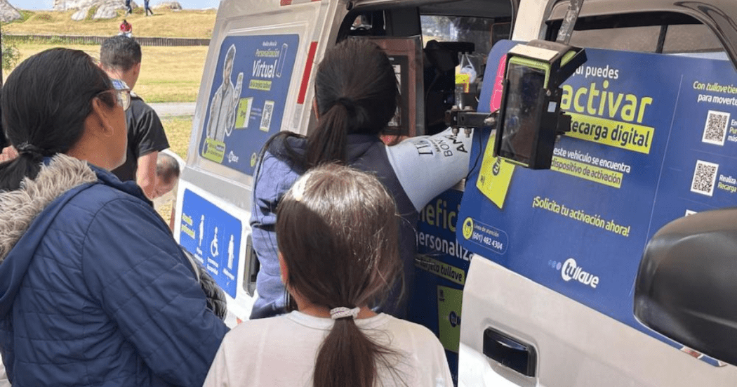 Imagen de personas al frente de una van recargando la tarjeta TuLlave