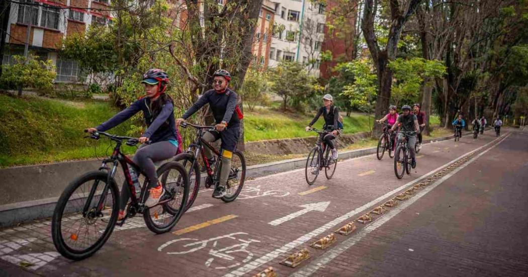 Foto de bogotanos y bogotanas usando bicicleta y circulando por una ciclorruta en Bogotá.