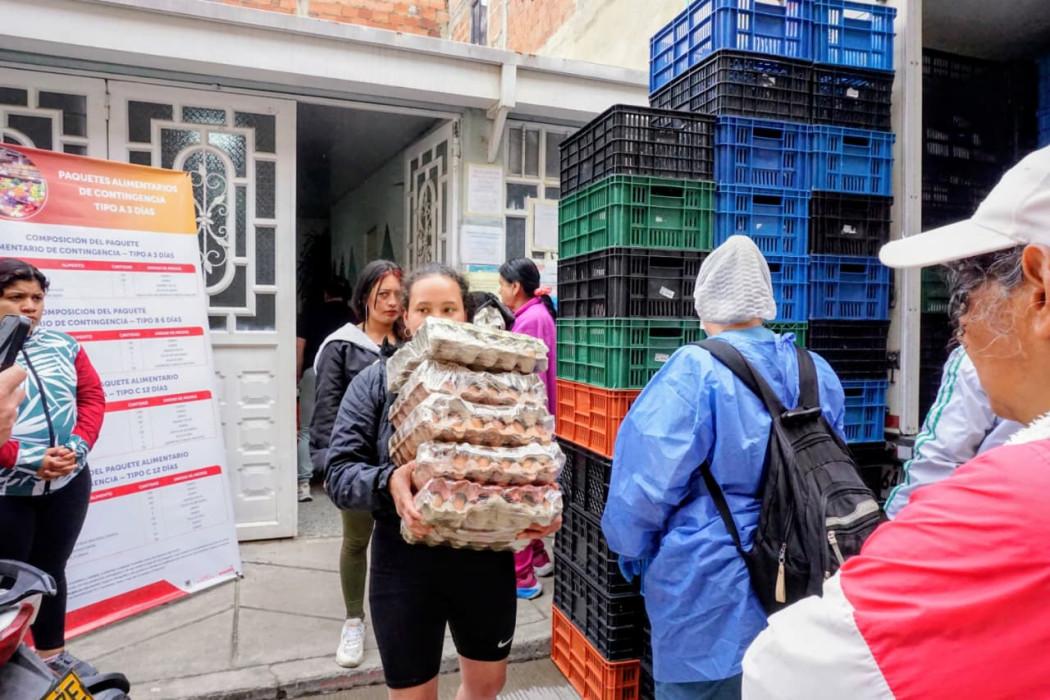 Imagen de varias personas cargando alimentos