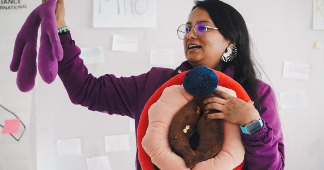 Mujer enseñando anatomía de los órganos sexuales femeninos.