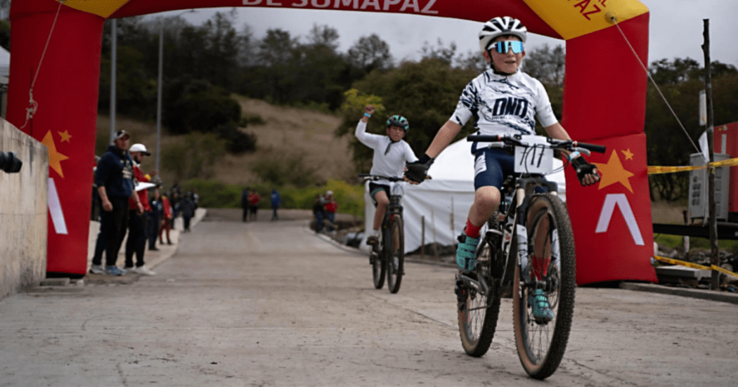 Imagen de un bicicrocista menor de edad pasando la línea de meta y celebrando
