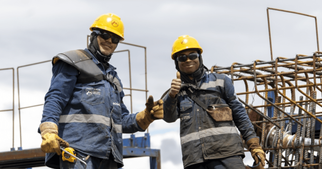 Imagean de dos trabajadores de la obra del Metro de Bogotá vestidos con su uniforme.