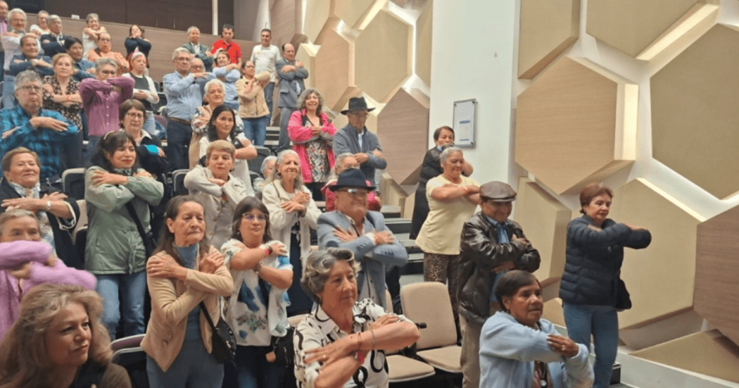 Foto de un grupo de adultos mayores en un auditorio 