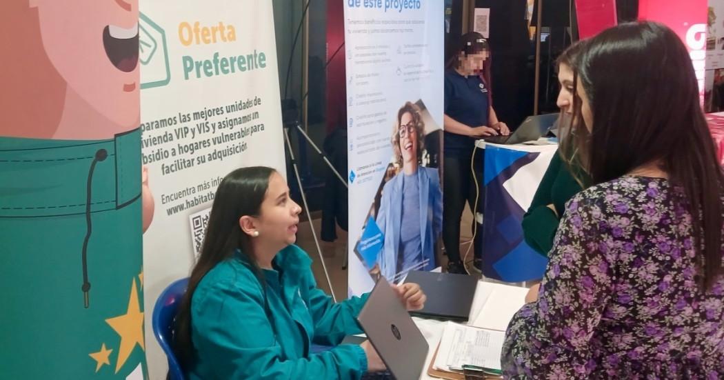 Foto que muestra personas hablando en una feria de vivienda en Bogotá.