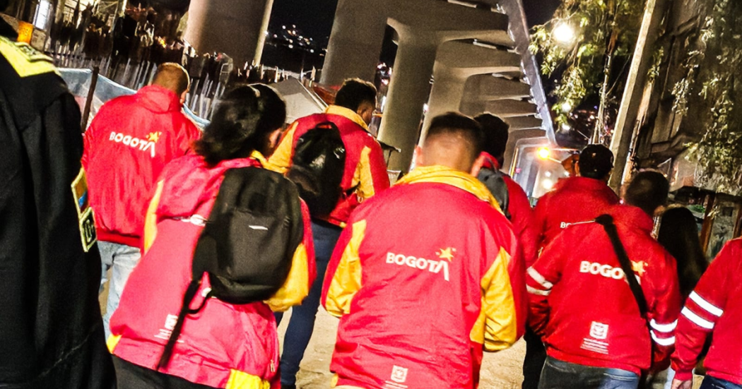 Imagen de funcionarios de la alcaldía local caminando por la Caracas en la noche