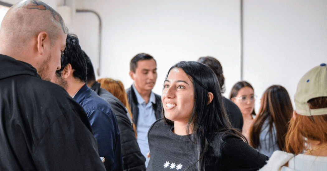 Imagen de una joven y un joven hablando y sonriendo
