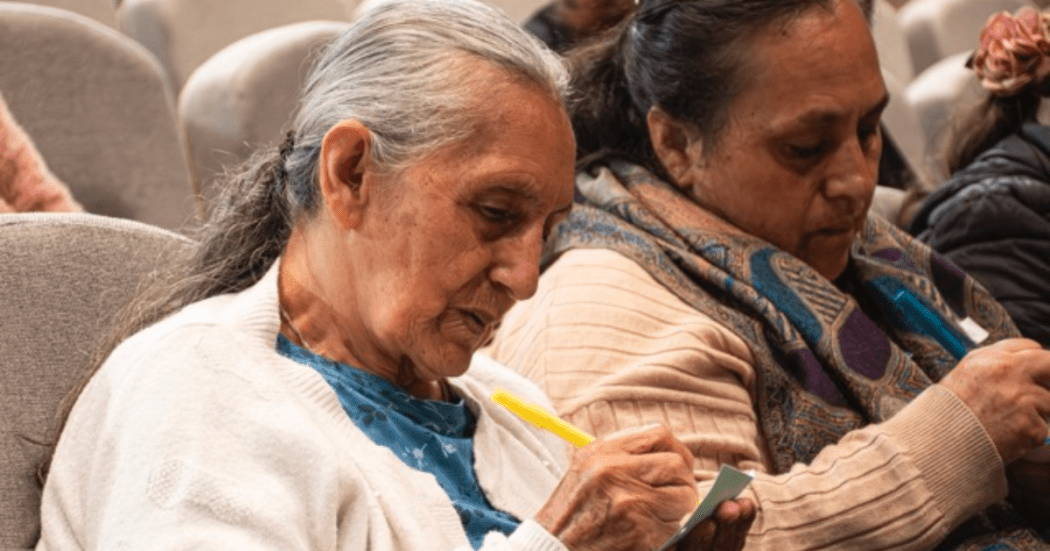 Imagen de dos señoras escribiendo en papeles
