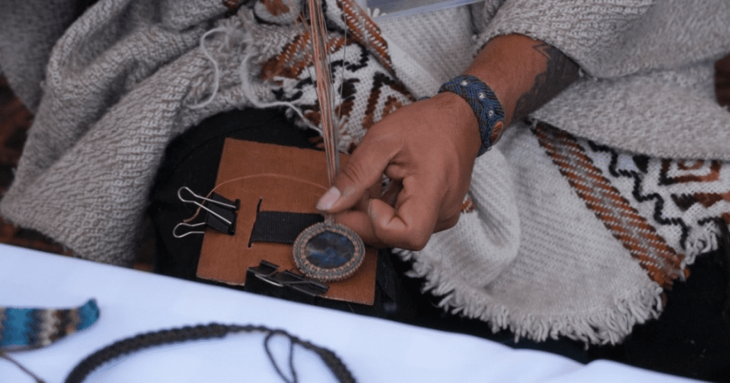 Imagen de unas manos que están trabajando en una artesanía en cuero.