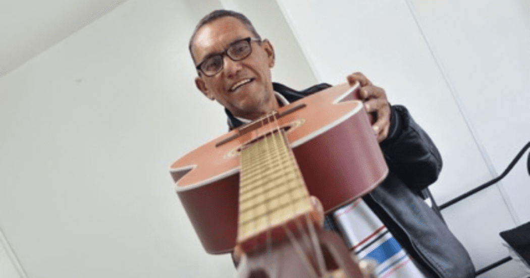 Imagen de Héctor mostrando su guitarra